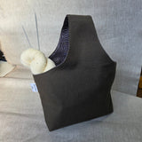 Khaki canvas bag with grey geometric interior on a neutral background