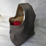 Khaki canvas bag with earth-tone interior on a neutral background